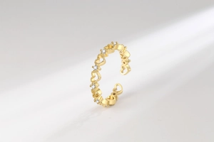 Vue détaillée d'une bague coeur doré évidée avec zircons brillants et anneau ouvert