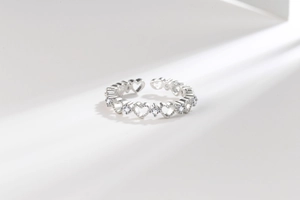 Vue détaillée de la bague coeur ajourée avec cristaux sur fond blanc minimaliste