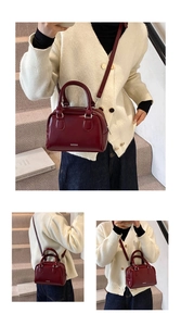 Detail of burgundy patent leather Boston bag with silver logo and glossy texture finish