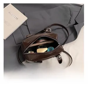 Internal capacity of dark brown leather mini Boston bag with phone and lipstick