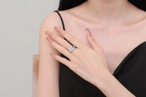 Close-up of silver ring with white enamel slogan Be Kind not a bitch and clear crystals