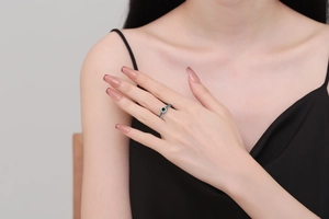 Retro silver ring with textured band and sparkling green zircon shown on finger