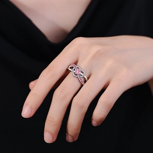 Silver infinity ring with pink heart zircon and pave stones worn by a model