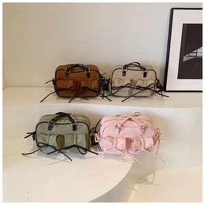 Détail de sacs bandoulière en toile avec poches à nœuds en plusieurs couleurs vintage
