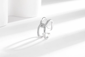 Macro shot of silver knot ring featuring sparkling micro-pave zircon on smooth metal surface