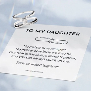 Detail of interlocking silver knot ring with sparkling stones and sentimental gift card