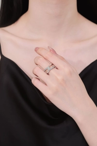 Detail of interlocking silver-tone knot ring with micro-pave zircon crystals on hand