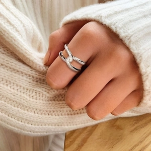 Close-up of elegant knotted cross ring with micro-pave cubic zirconia on a model's hand