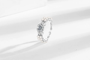 Gros plan détaillé d'une bague nœud en argent avec perles blanches et fleurs en cristal
