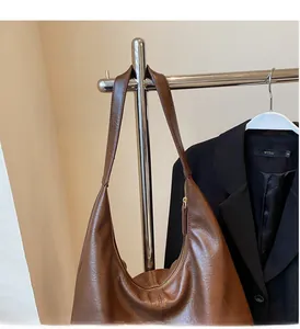 Detail of the soft brown PU leather texture and wide shoulder strap of the tote bag