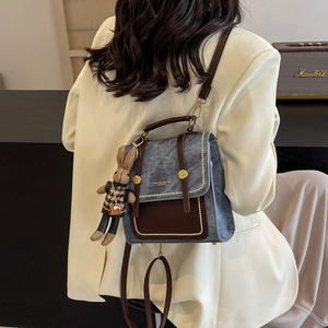 Retro-Rucksack mit Kontrastfarben aus blauem Denim und braunem Leder mit Hasenanhänger