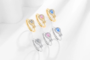 Detailed view of pear-cut zircon rings in gold and silver with halo setting and micro-pave