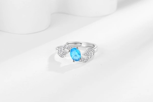 Detailed macro shot of adjustable leaf ring with blue gemstone and white zirconias