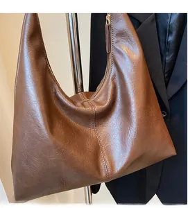 Detail of dark brown faux leather hobo tote bag with soft texture and retro zipper design