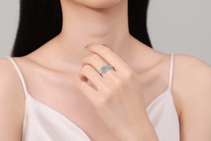 Close-up of a silver ring with pear-shaped cubic zirconia and halo setting on a finger