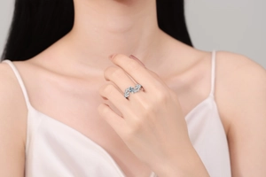 Detail view of silver leaf engagement ring with round zircon worn by a female model