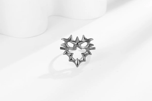 Detail of Y2K punk style thorn heart ring with star motif and matte silver finish