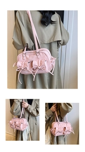 Détail du sac à bandoulière rose avec nœuds décoratifs et doubles poches avant de rangement