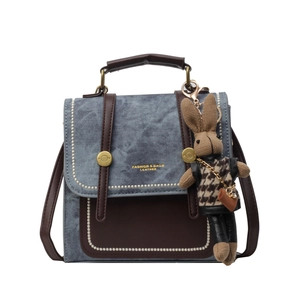 Retro Damenhandtasche aus blauem Denim und braunem Leder mit süßem Hasenanhänger