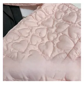 Close-up of pink heart-quilted fabric detail on a large padded puffer shoulder bag