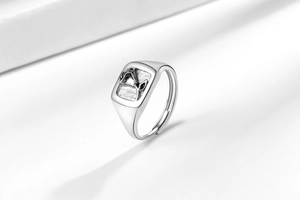Macro detail of silver adjustable ring featuring a square embossed floral art design