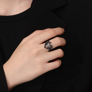 Gothic black thorn heart ring with sparkling center gemstone on a model hand