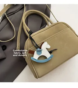 Detail of trendy mini Boston bag with soft durable fabric and leather horse charm
