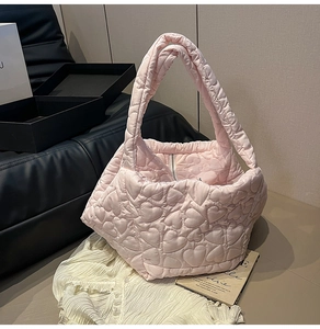 Close-up of light pink quilted tote bag featuring a decorative heart stitch pattern