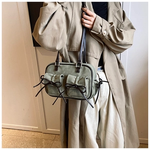 Detail showing vintage green shoulder bag with dark brown bows and small pockets