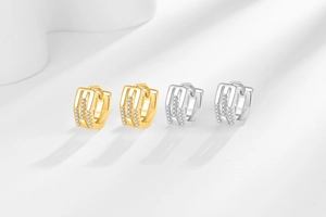 Vue détaillée de boucles d'oreilles huggie géométriques en or et argent avec zircons