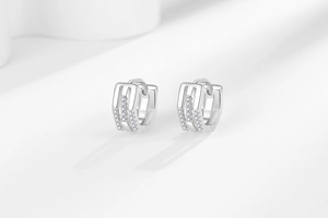 Gros plan de boucles d'oreilles créoles évidées en zircon et finition or blanc poli