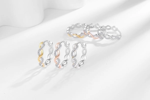 Macro shot of twisted hoop earrings with micro-paved zircons in silver and gold finishes