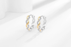 Detailed view of two-tone twisted hoop earrings with micro-set sparkling white crystals
