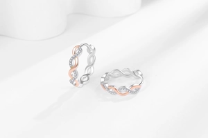 Detail of twisted hoop earrings in S925 silver with rose gold and micro-set cubic zirconia