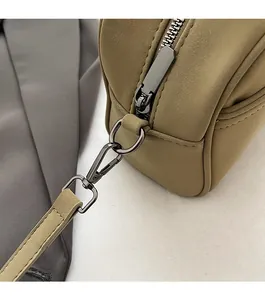 Detailed macro view of matte gun-black hardware and smooth earth-tone handbag texture