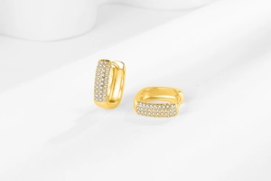 Macro detail of gold-plated hoop earrings with three rows of micro-paved cubic zirconia
