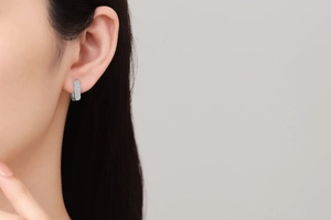 Macro side view of silver huggie earring with triple-row micro-pave white zircon stones