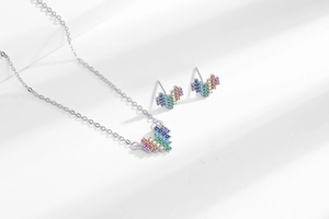 Macro shot of pixel heart jewelry set with vibrant rainbow cubic zirconia inlay