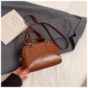 Close-up of brown vintage Boston bag with glossy finish and silver-tone hardware accents
