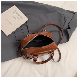 Top view of vintage brown leather bag with dual zippers, silver hardware and strap