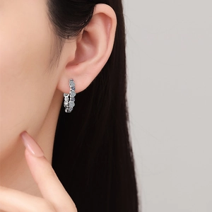 Silver hoop earrings with blue evil eye and heart patterns featuring cubic zirconia