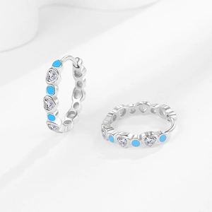 Silver hoop earrings featuring heart-shaped zircons and blue evil eye accents