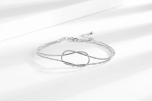 Detailed macro view of silver snake chain bracelet with knot clasp and lobster closure
