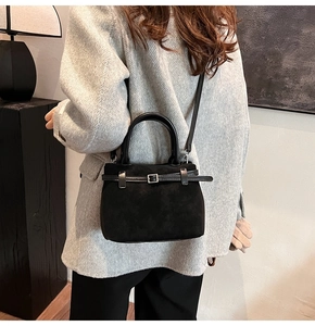 Mini black suede tote bag with strap shown on model in grey winter coat