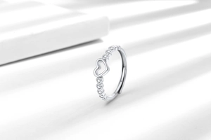 Gros plan d'une bague coeur argentée ajustable avec des pierres en zircone cubique