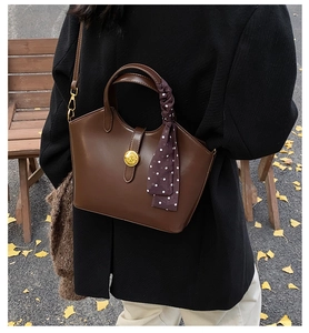 Détail d'un sac cabas en cuir marron avec foulard à pois et fermoir doré en décor automne