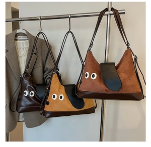 Dettaglio di tre borse stile cartone animato in marrone, giallo e rosso con alette a forma di orecchie