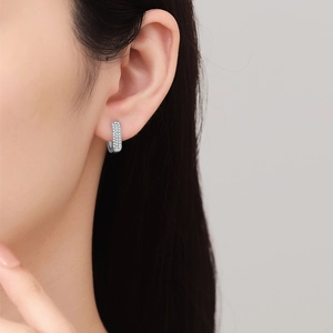 Silver micro-pave cubic zirconia hoop earrings for men and women on model's ear