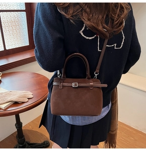 Detailed back view of a vintage dark brown frosted leather handbag with adjustable strap