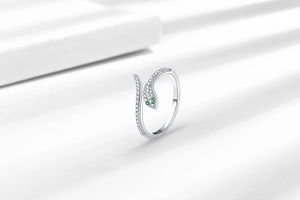 Detail of silver layered snake ring with green stone eyes and white cubic zirconia